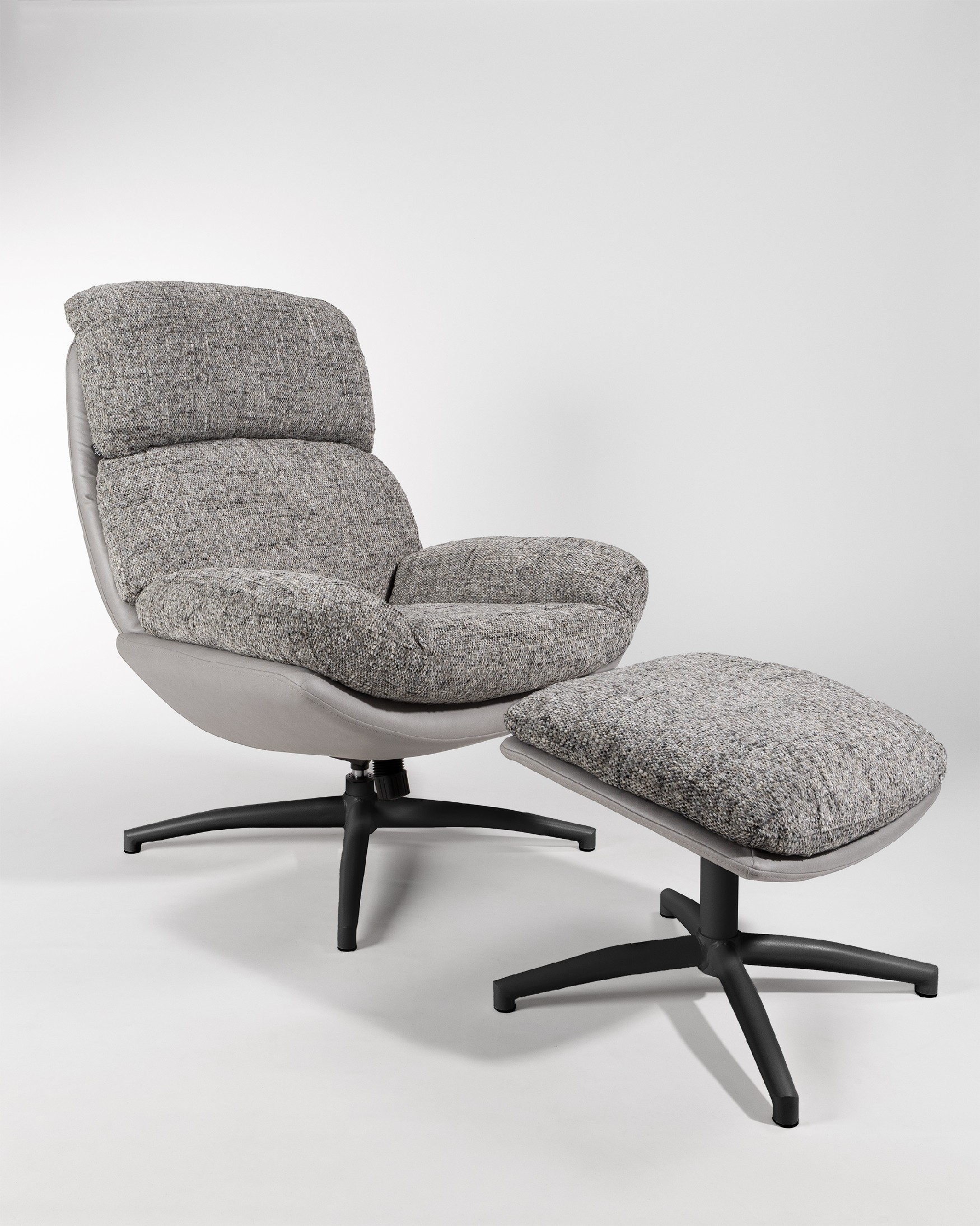 Fauteuil Denia avec rembourrage gris et tempête avec pouf en structure métallique noire, basculant et tournant à 360°.