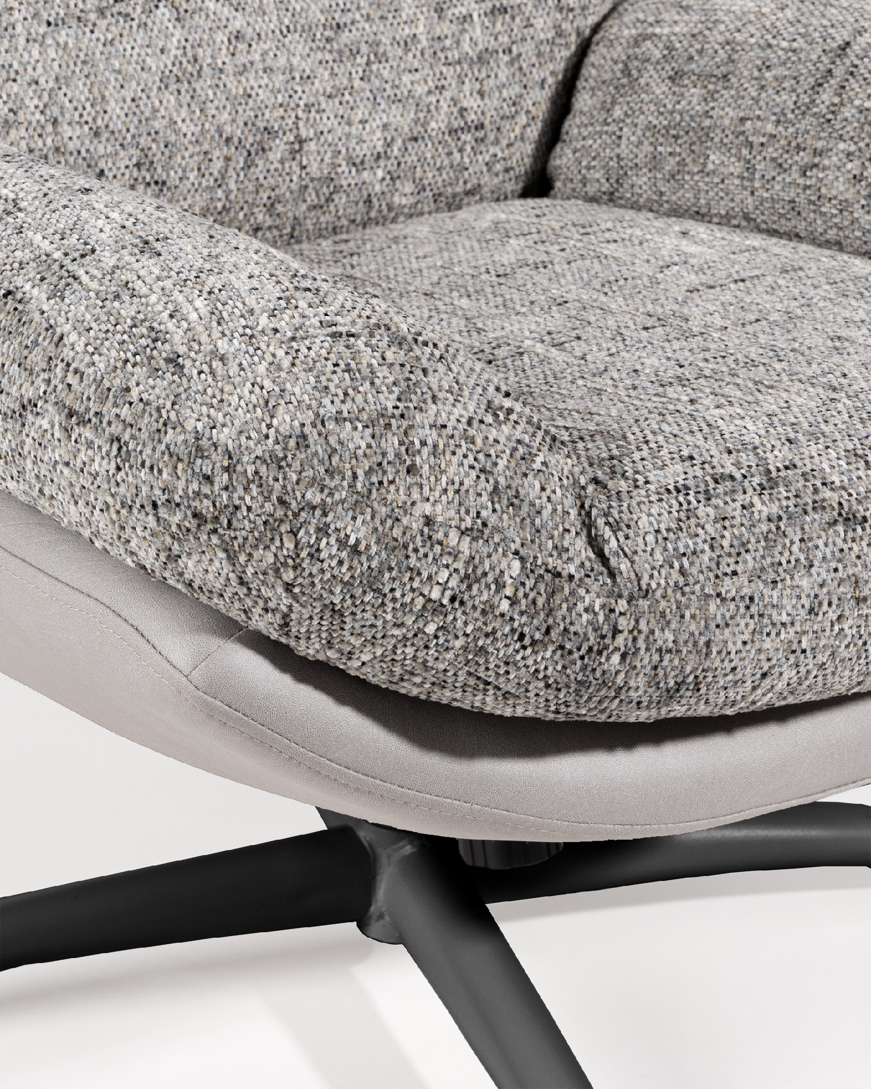 Fauteuil Denia avec rembourrage gris et tempête avec pouf en structure métallique noire, basculant et tournant à 360°.