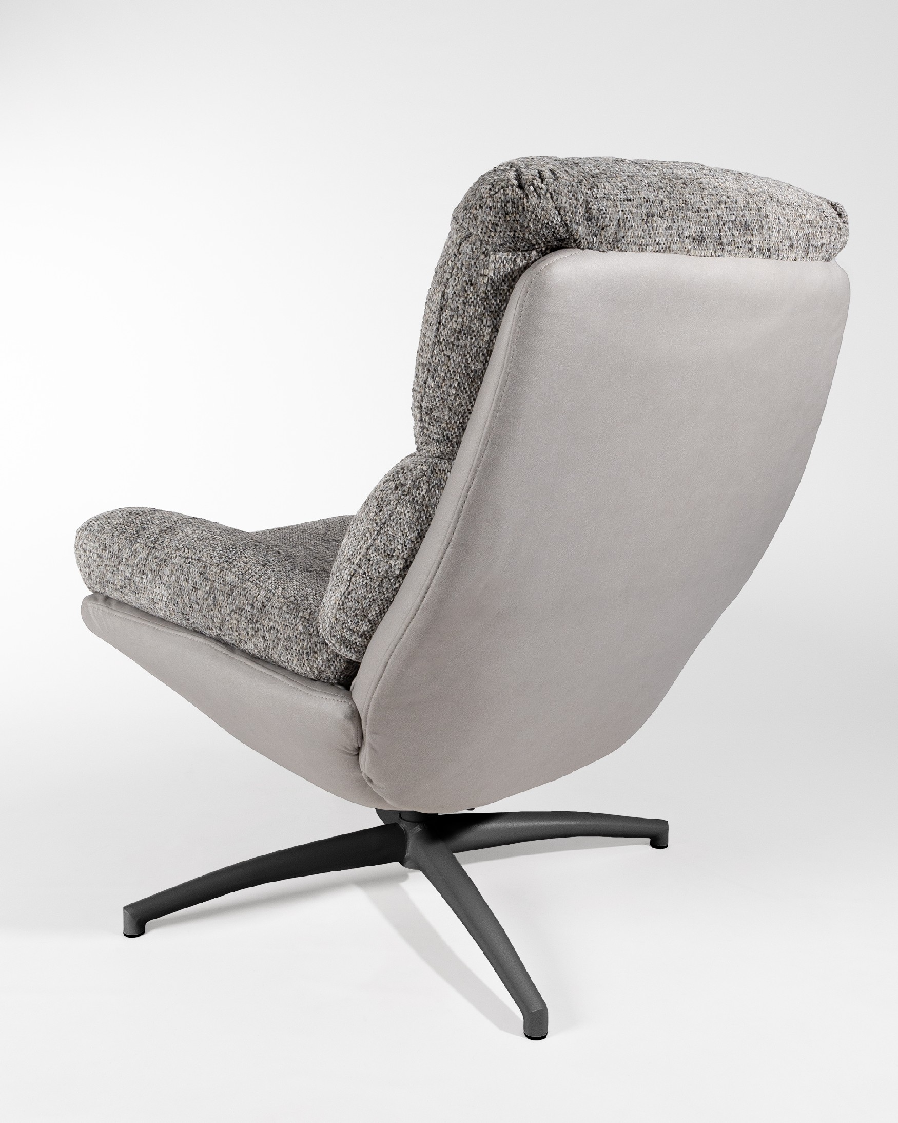 Fauteuil Denia avec rembourrage gris et tempête avec pouf en structure métallique noire, basculant et tournant à 360°.