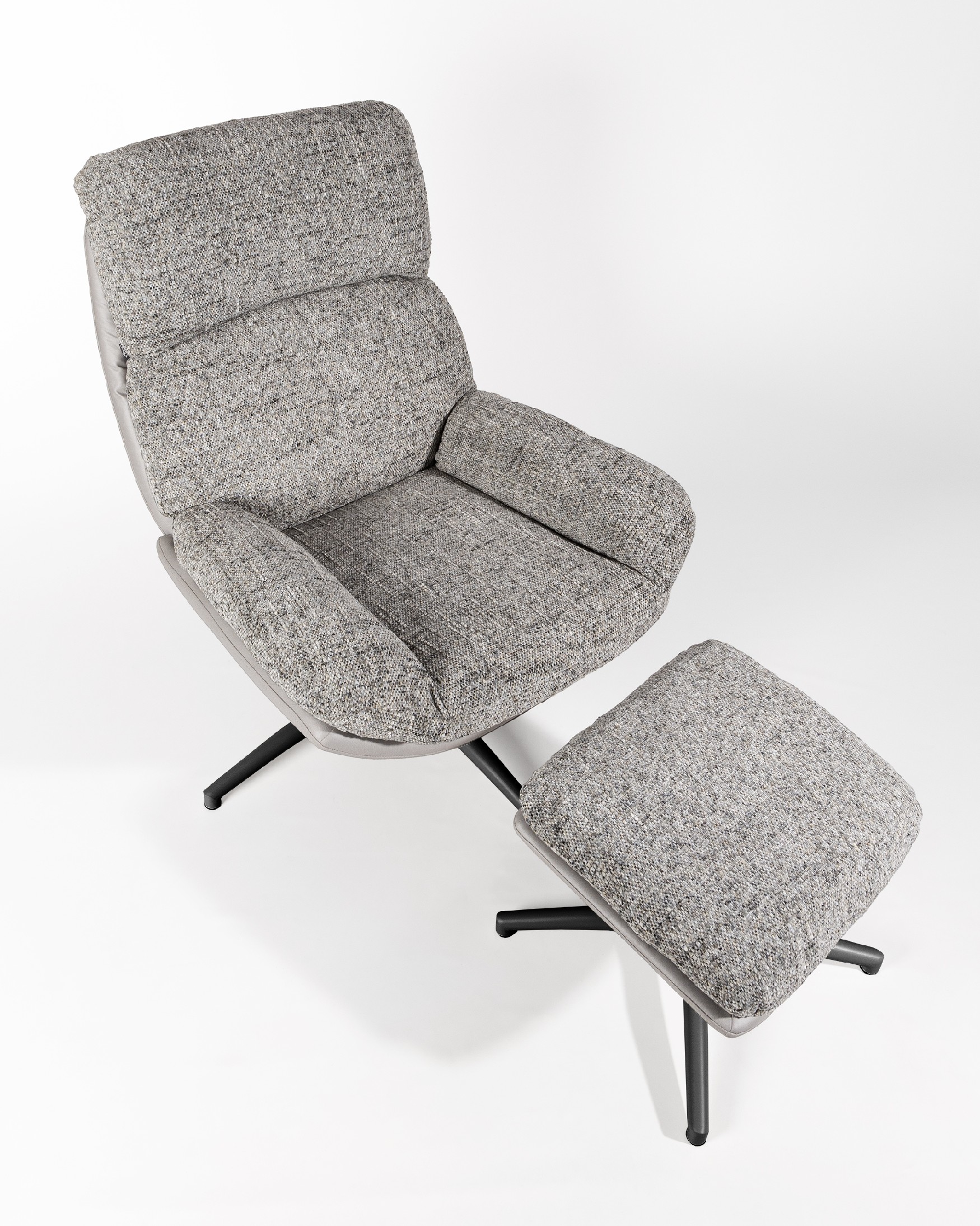 Fauteuil Denia avec rembourrage gris et tempête avec pouf en structure métallique noire, basculant et tournant à 360°.