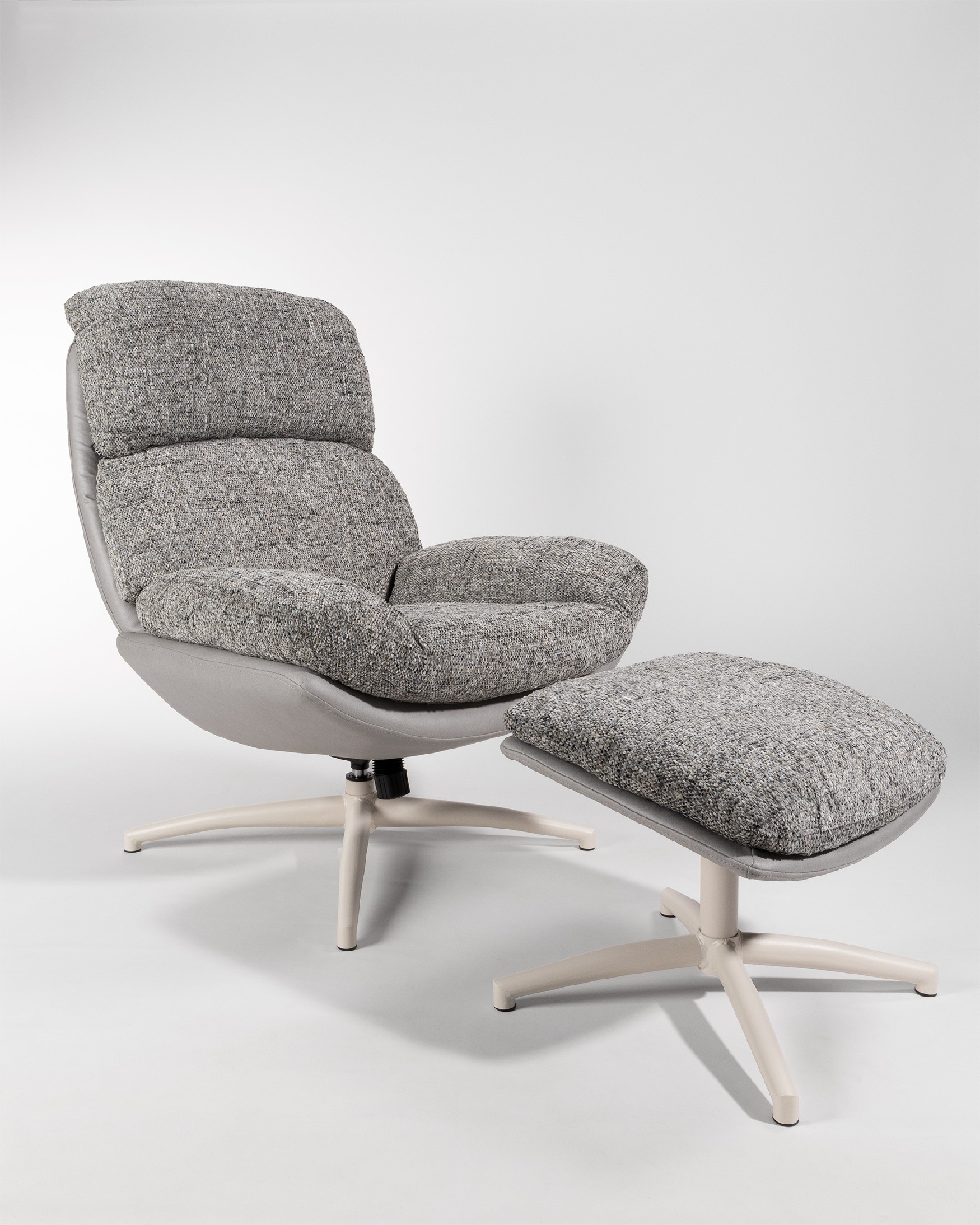Fauteuil Fresia avec un revêtement gris et tempête avec un pouf à structure métallique ivoire, basculant et rotatif à 360°.