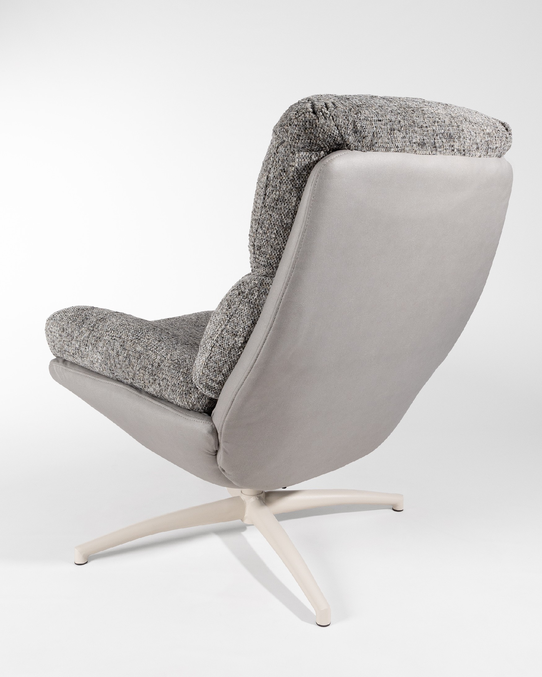 Fauteuil Fresia avec un revêtement gris et tempête avec un pouf à structure métallique ivoire, basculant et rotatif à 360°.