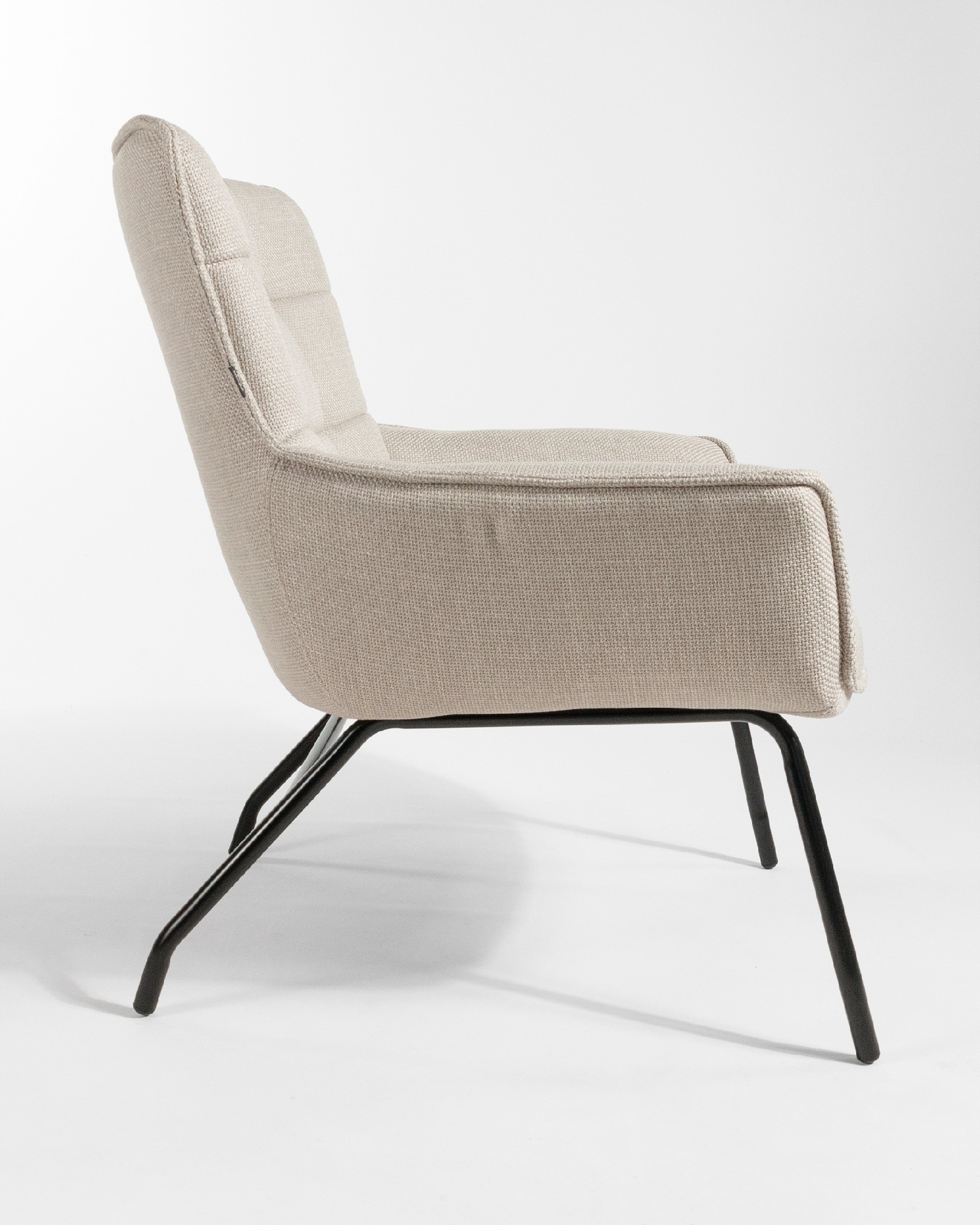 Fauteuil Dalia avec un revêtement perlé et des pieds en métal noir
