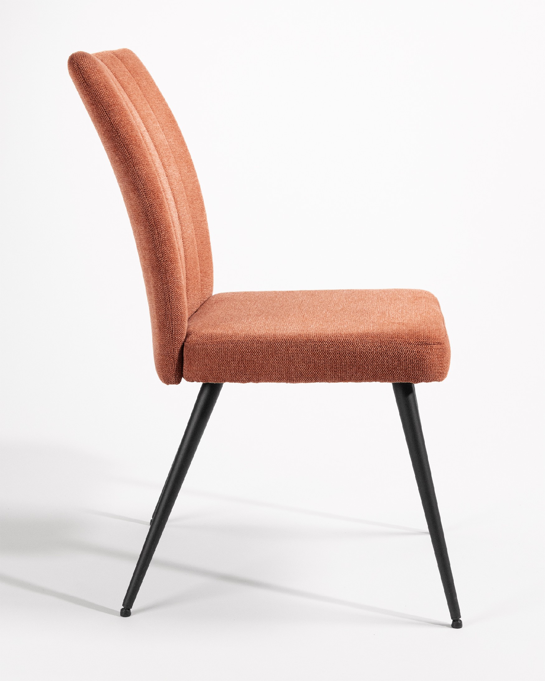 Chaise Dallas avec un revêtement saumon et des pieds métalliques noirs