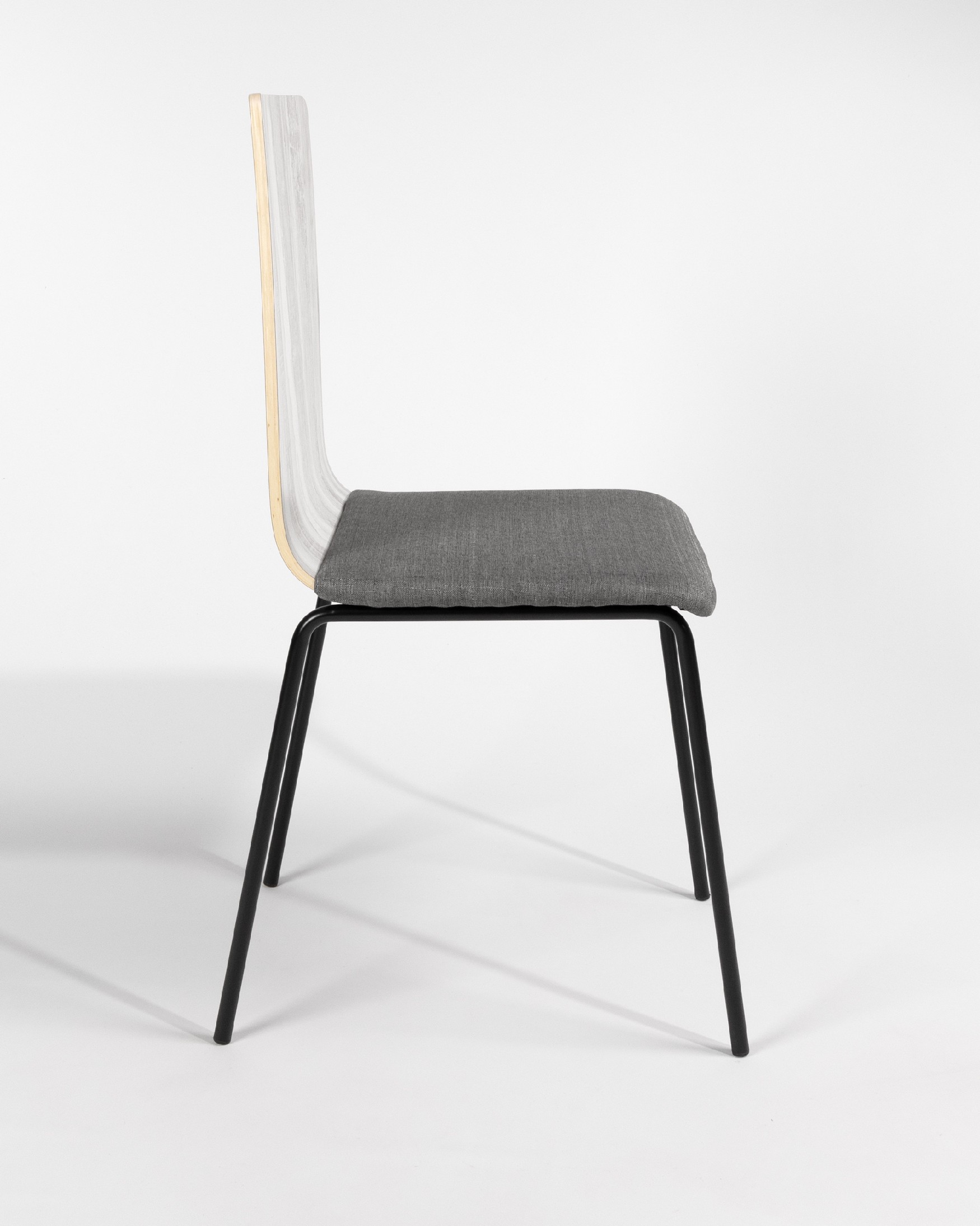 Dubai chair with gray upholstery, articulated backrest, and black metal legs