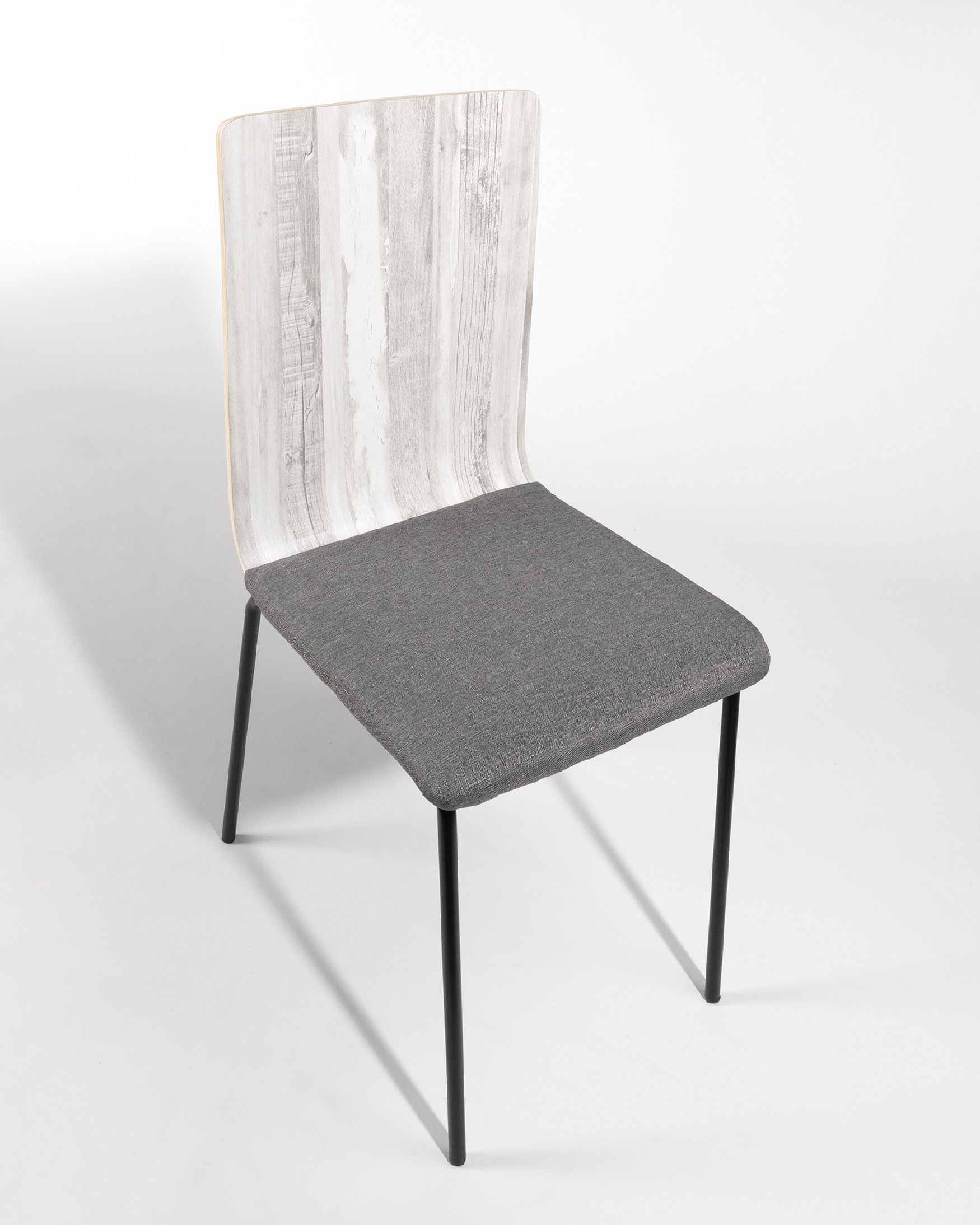 Dubai chair with gray upholstery, articulated backrest, and black metal legs