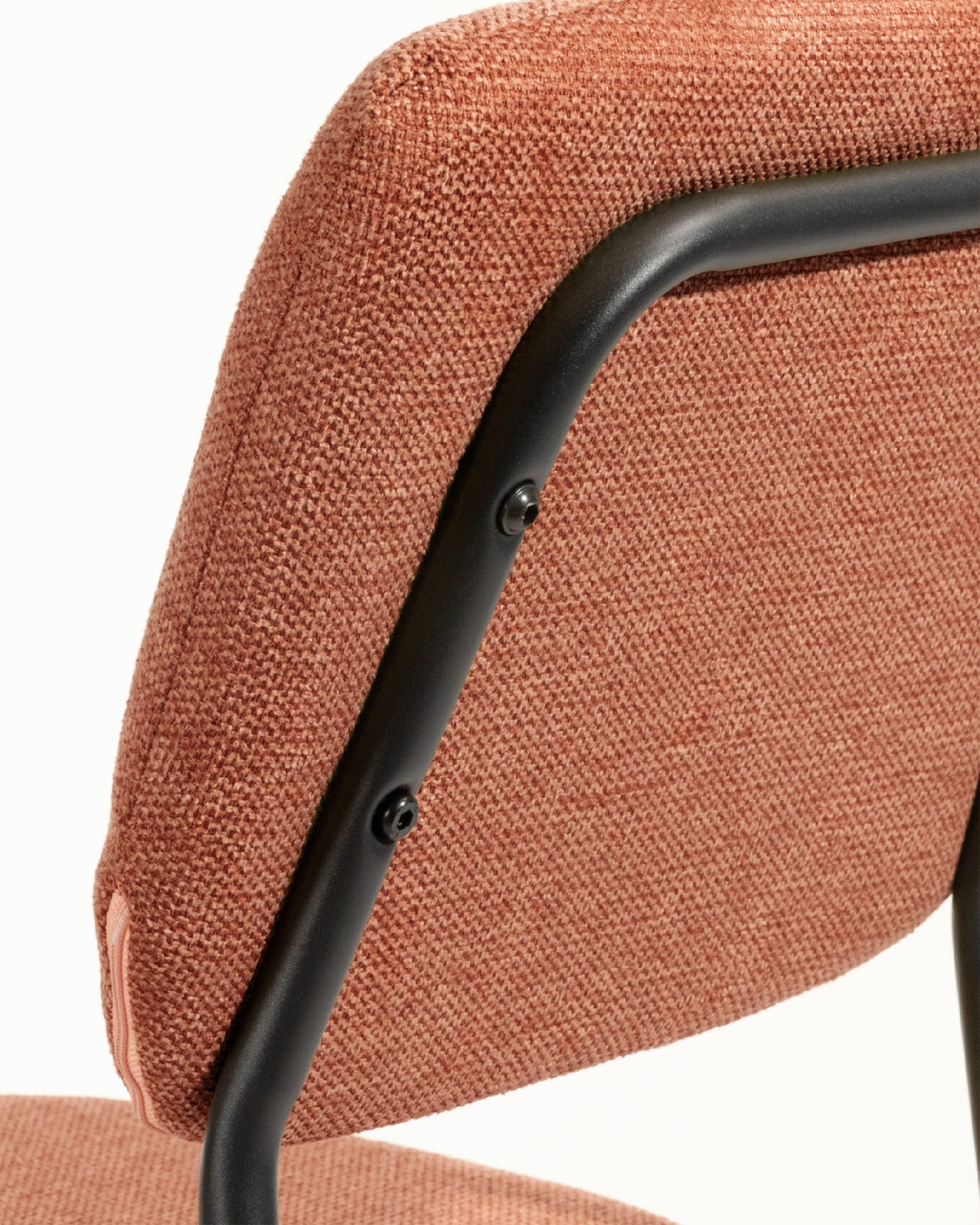 Chaise Kobe avec un revêtement saumon et des pieds métalliques noirs
