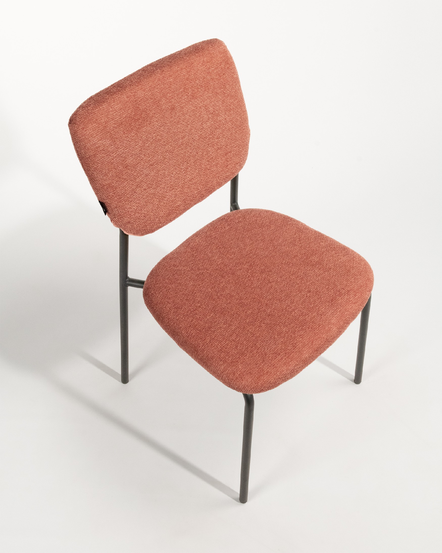 Chaise Kobe avec un revêtement saumon et des pieds métalliques noirs