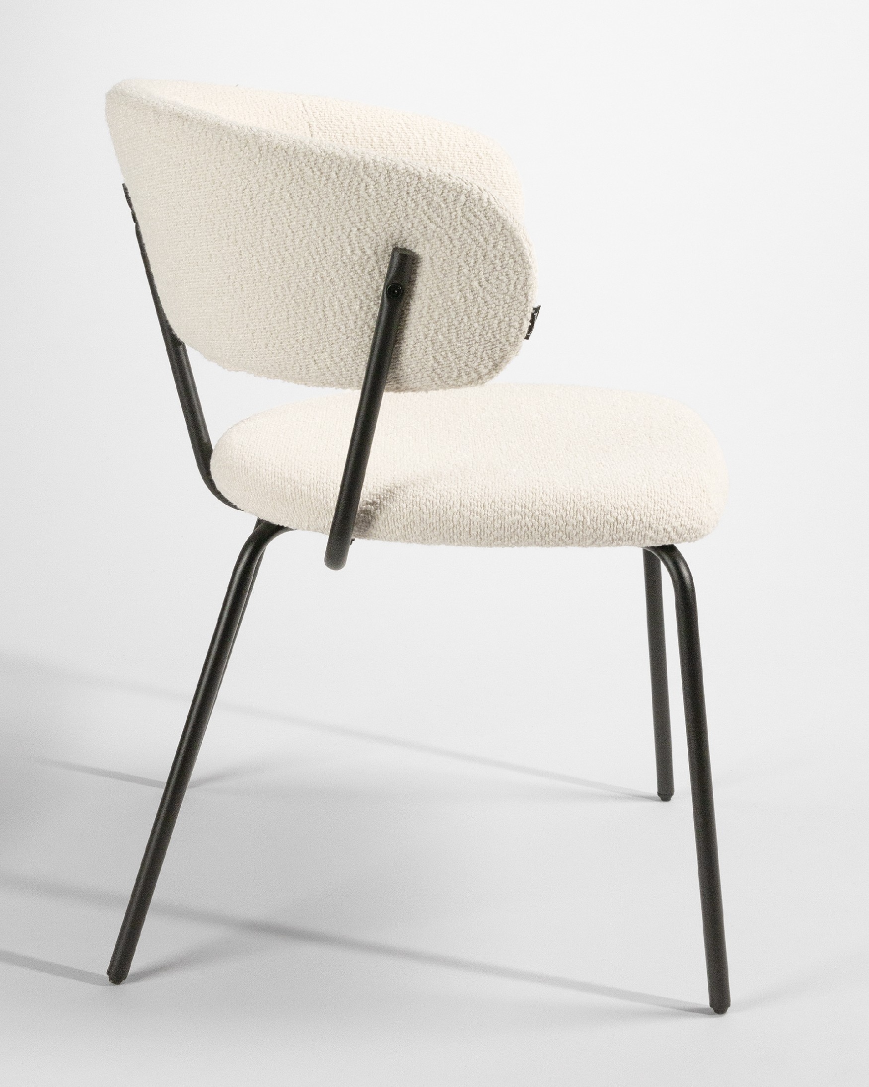 Quebec chair with off-white upholstery and black metal legs